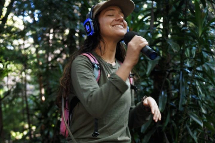 a person standing next to a forest