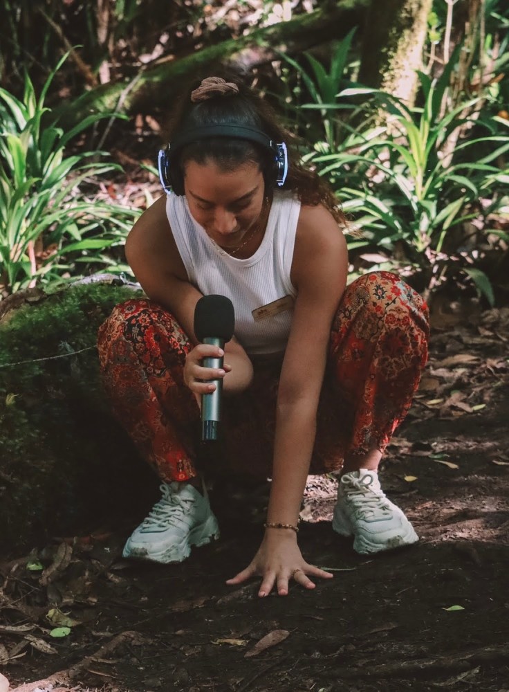 a person standing next to a palm tree