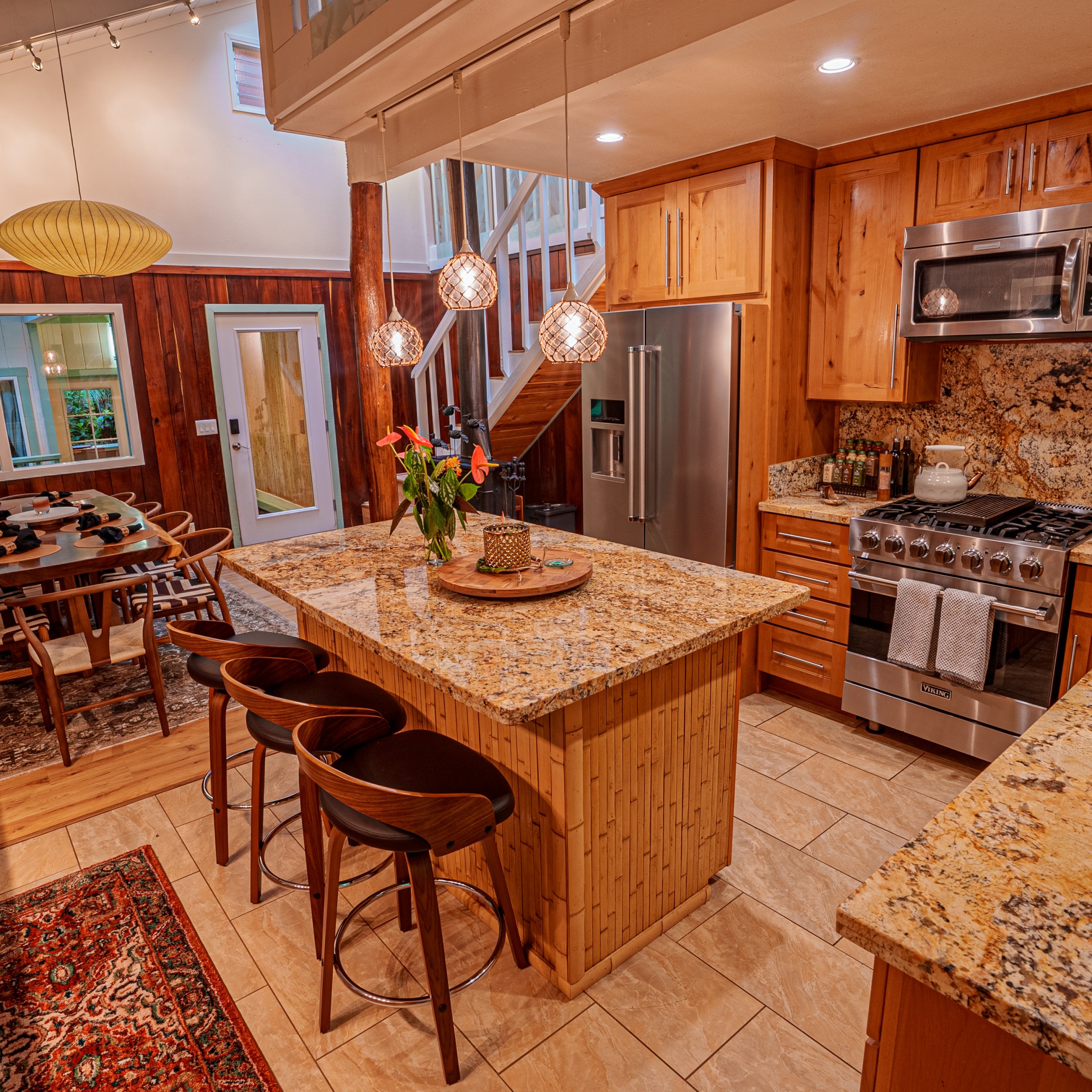 Rustic kitchen with wooden cabinets, granite countertops, and pendant lights.